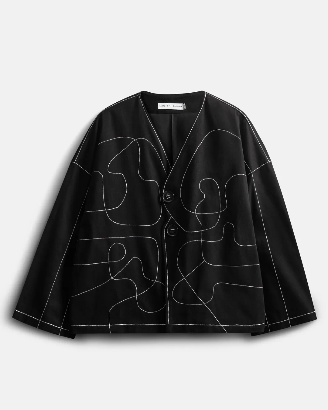 Jaket kolaborasi tampak depan: leher V tanpa kerah, dua kancing, garis Ryan dijahit benang putih.