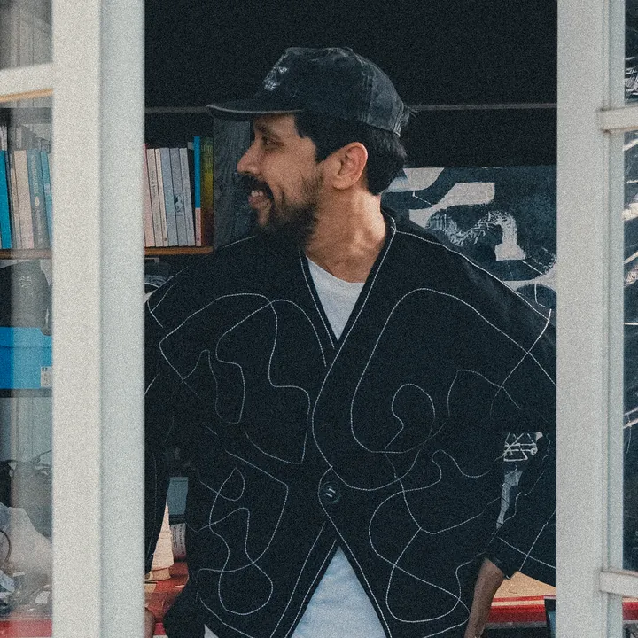 Ryan Geraldin memakai jaket kolaborasi di studionya.